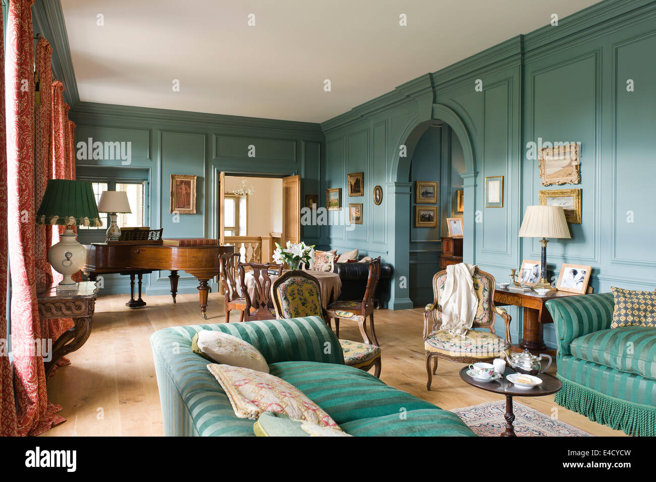 A Bechstein piano stands at the far end of a blue drawing room. The wall paint is by Farrow and Ball Stock Photo