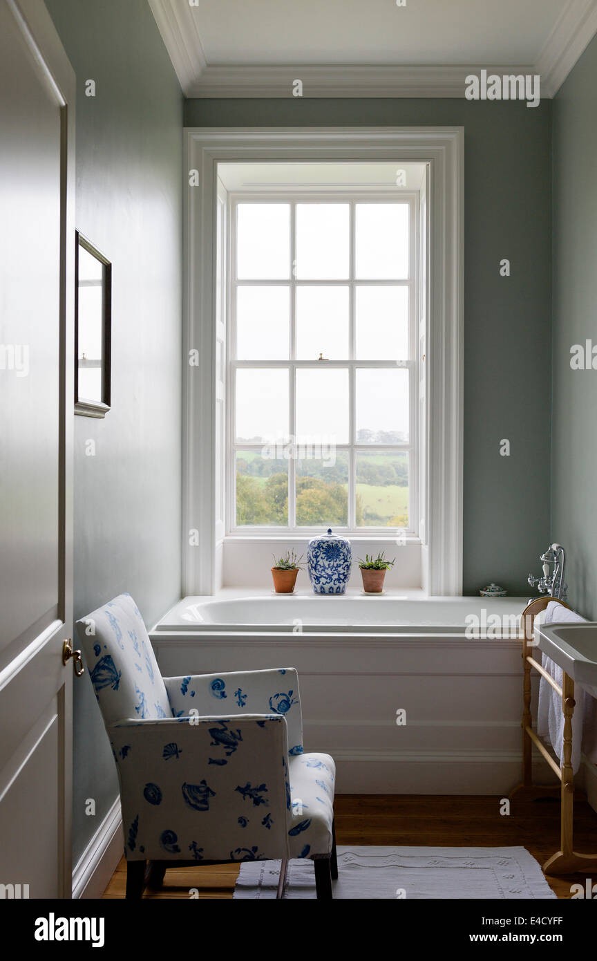 White armchair with blue bloc print in bathroom with walls painted in Farrow and Ball Stock Photo