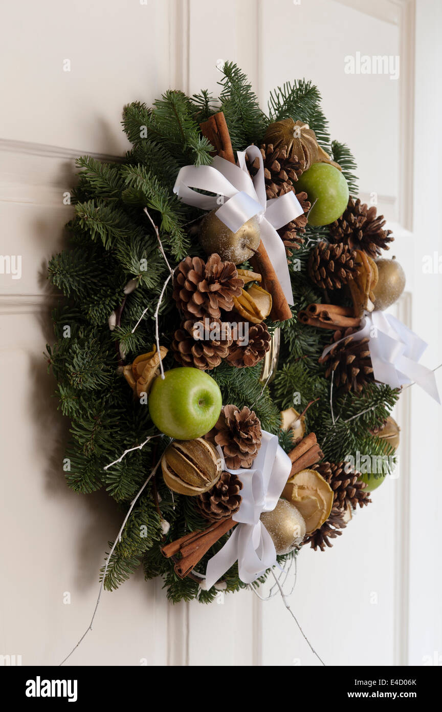 Christmas wreath on front door with pine cones and apples, designed by florists Hayford & Rhodes Stock Photo