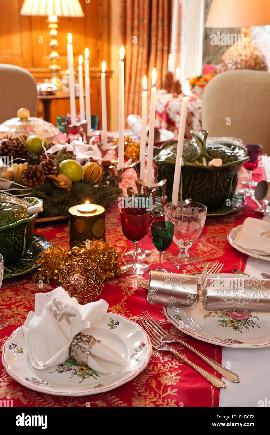 Table laid for christmas dinner with candles and decorations. The tableware is a mix of Luneville Old Strasbourg pattern china a Stock Photo