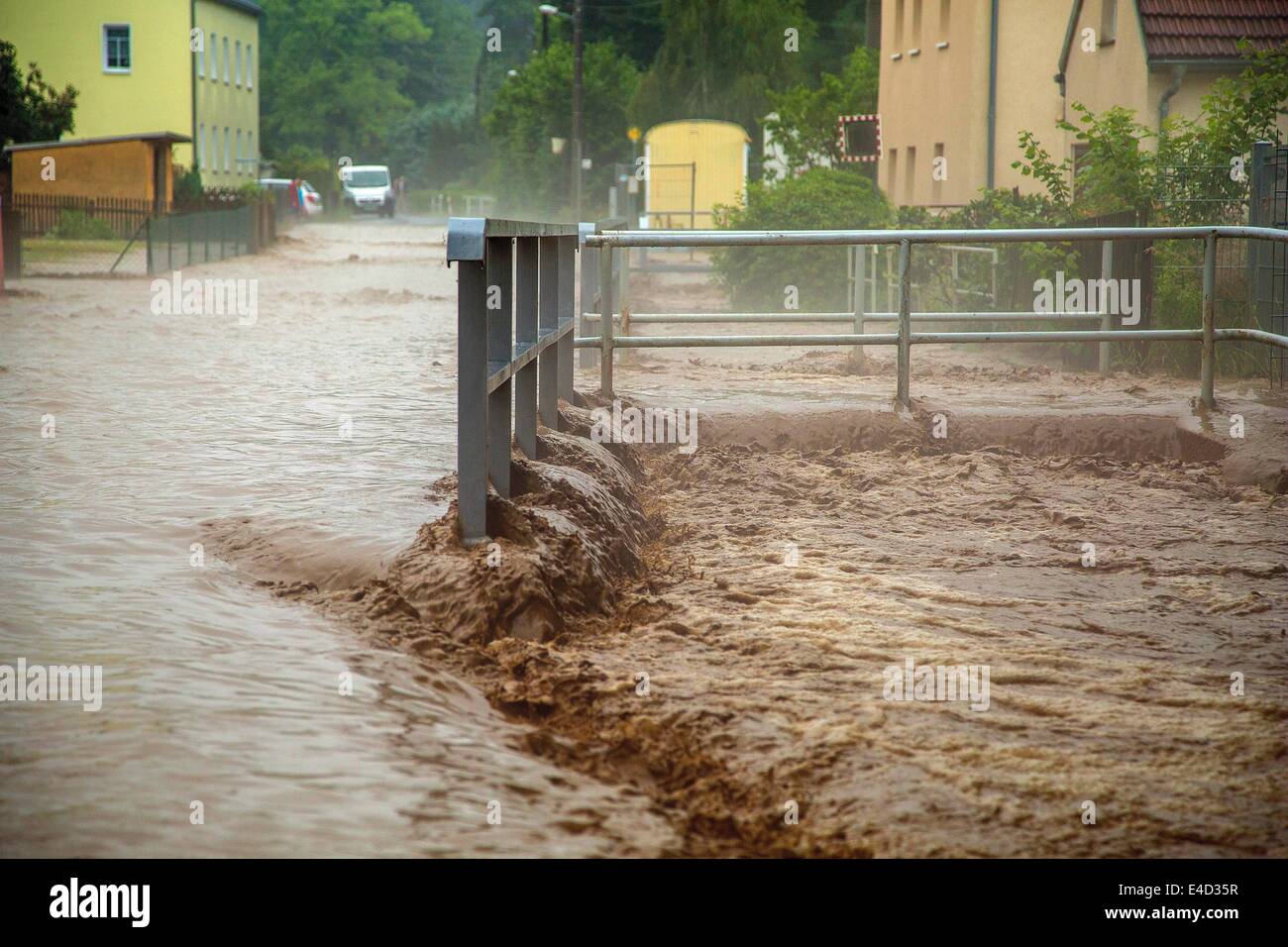 Muehlau, Germany. 08th July, 2014. A flooded street in Muehlau, Germany, 08 Juli 2014. Storms with heavy rainfalls flooded streets and basements in Saxony, Saxony-Anhalt and Thuringia in the night before Wednesday. Photo: Jens Uhlig/dpa/Alamy Live News Stock Photo
