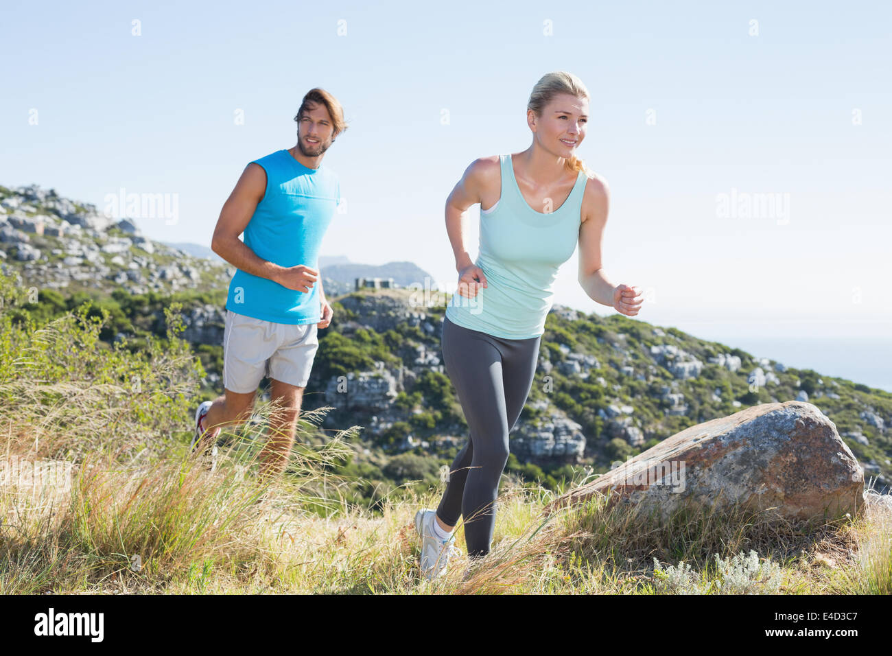 Fit couple jogging through countryside Stock Photo