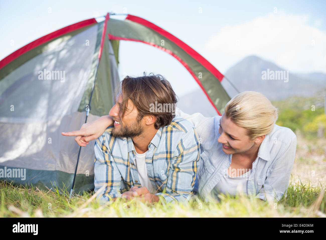 Attractive couple lying in their tent looking at something Stock Photo