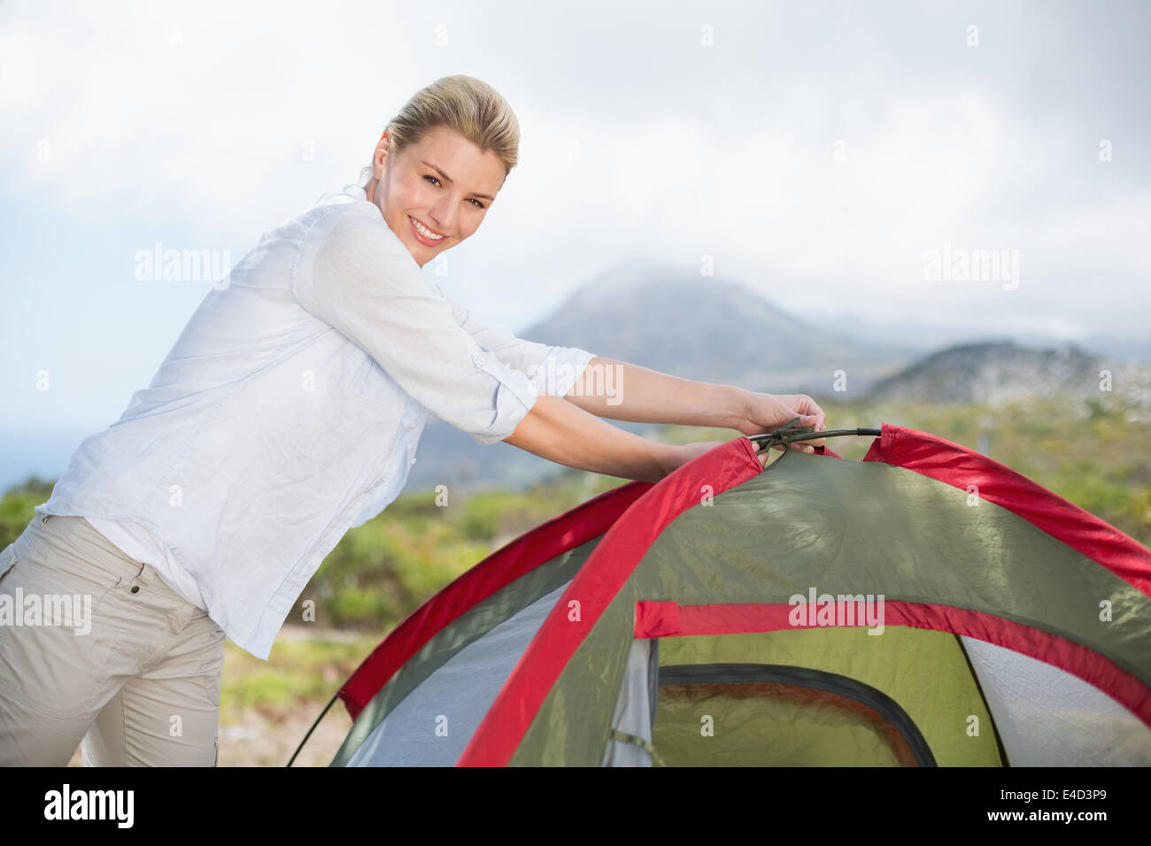 Attractive blonde setting up her tent Stock Photo
