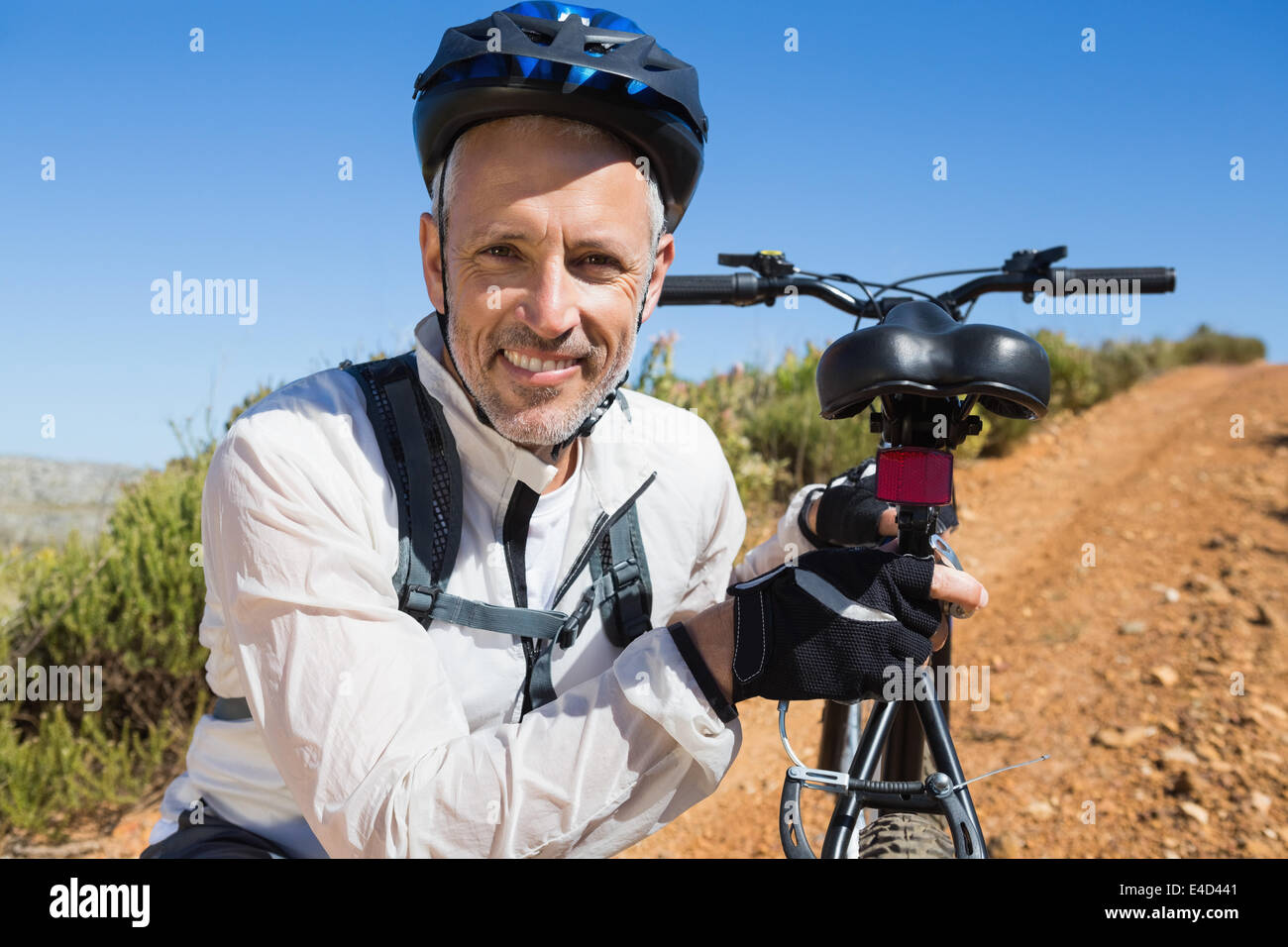 Fit cyclist carrying his bike on country terrain Stock Photo - Alamy