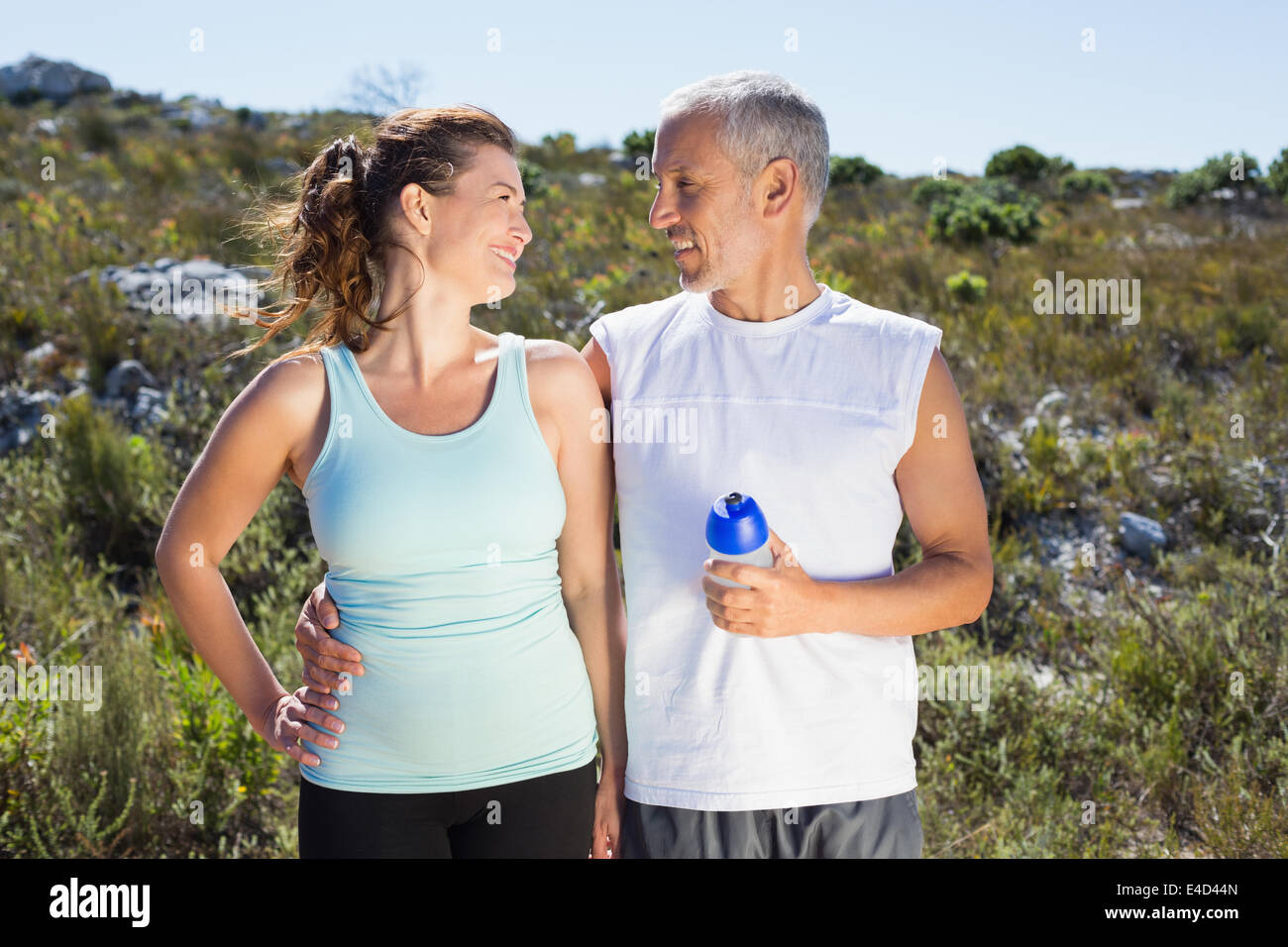 Active couple embracing each other on a jog in the country Stock Photo