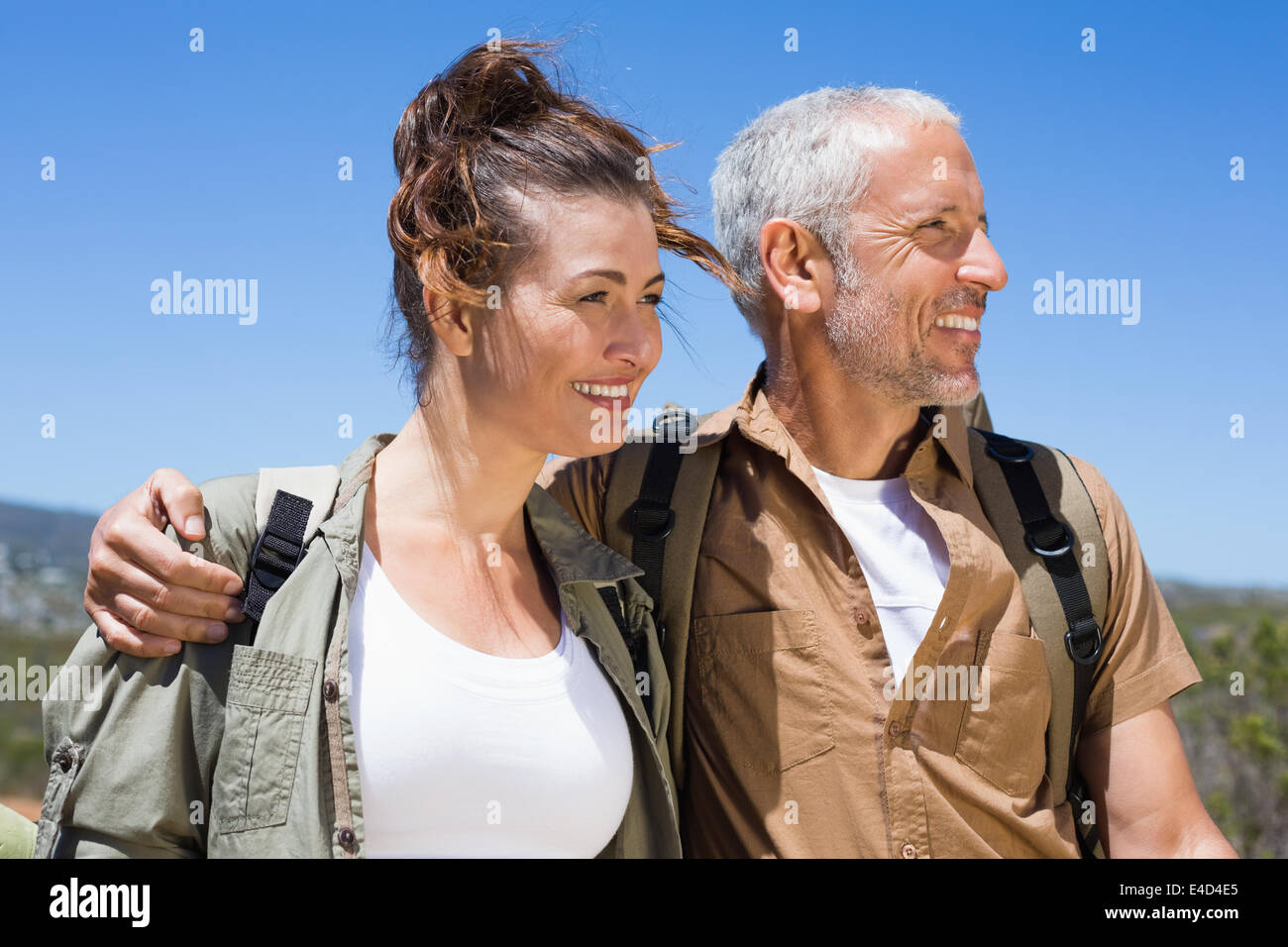 Hiking couple smiling together on mountain trail Stock Photo - Alamy