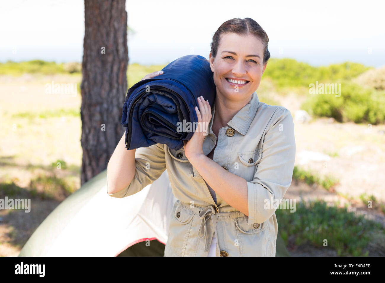 Outdoorsy woman smiling at camera outside her tent Stock Photo