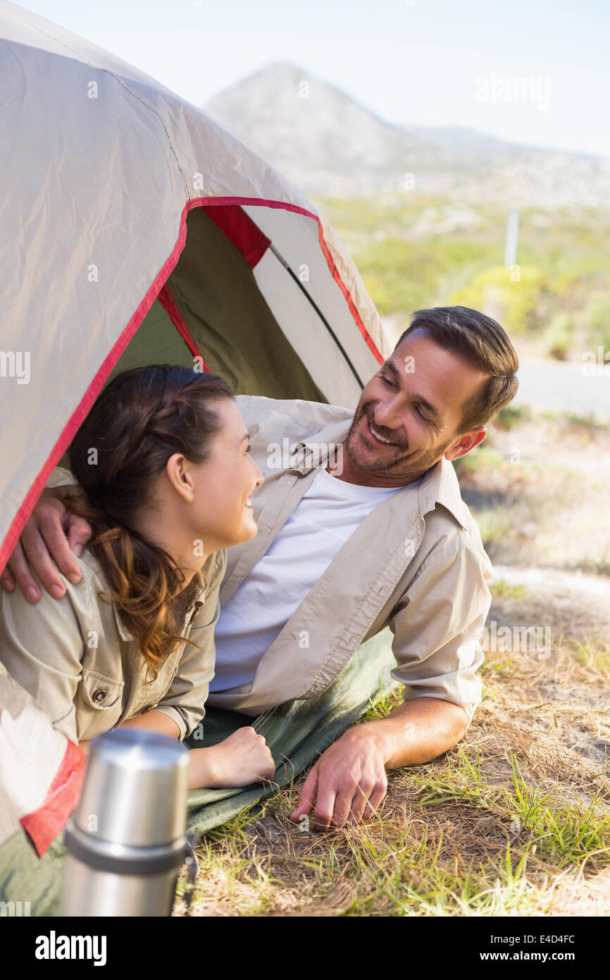 Outdoorsy couple smiling at each other inside their tent Stock Photo
