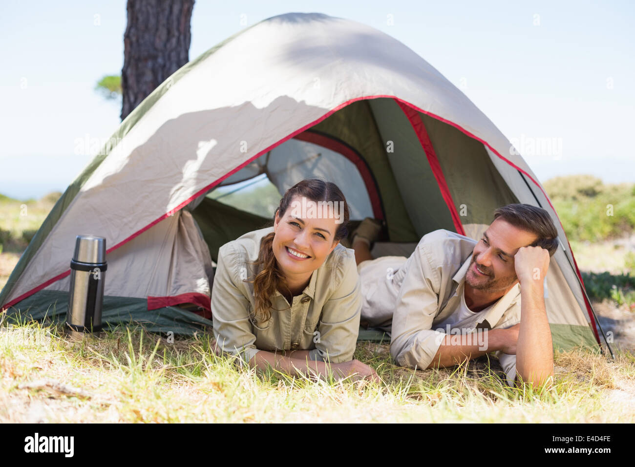 Outdoorsy couple smiling at camera inside their tent Stock Photo