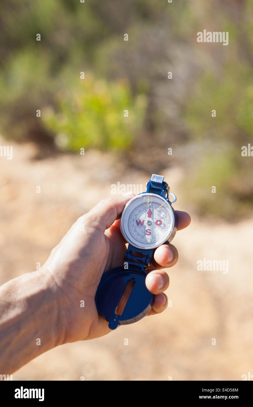 Hiker holding his compass in the countryside Stock Photo