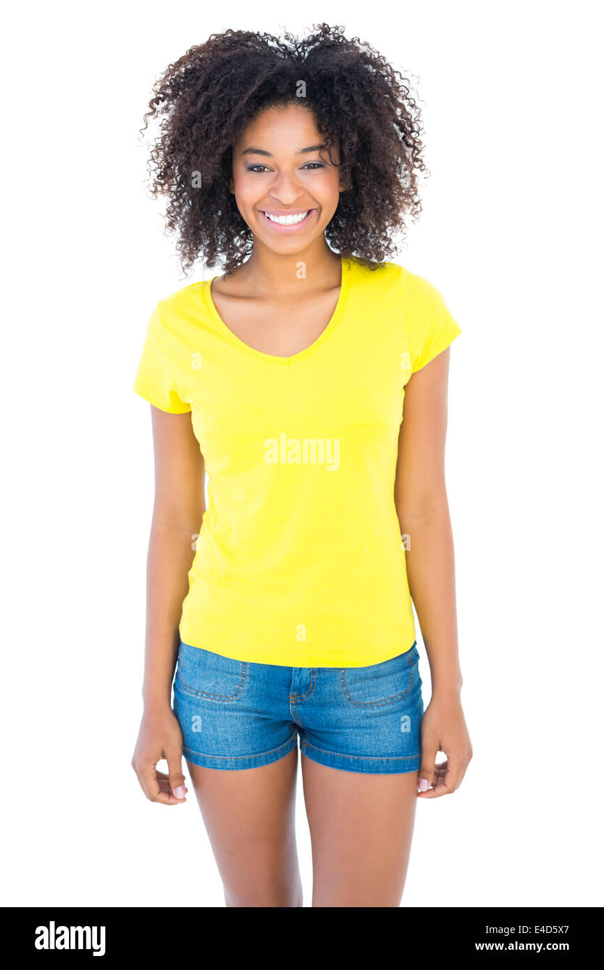 Pretty girl in yellow tshirt and denim hot pants smiling at camera Stock Photo