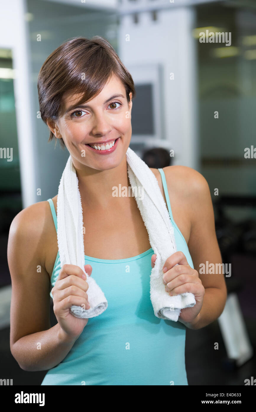 Fit brunette smiling at camera with towel around shoulders Stock Photo