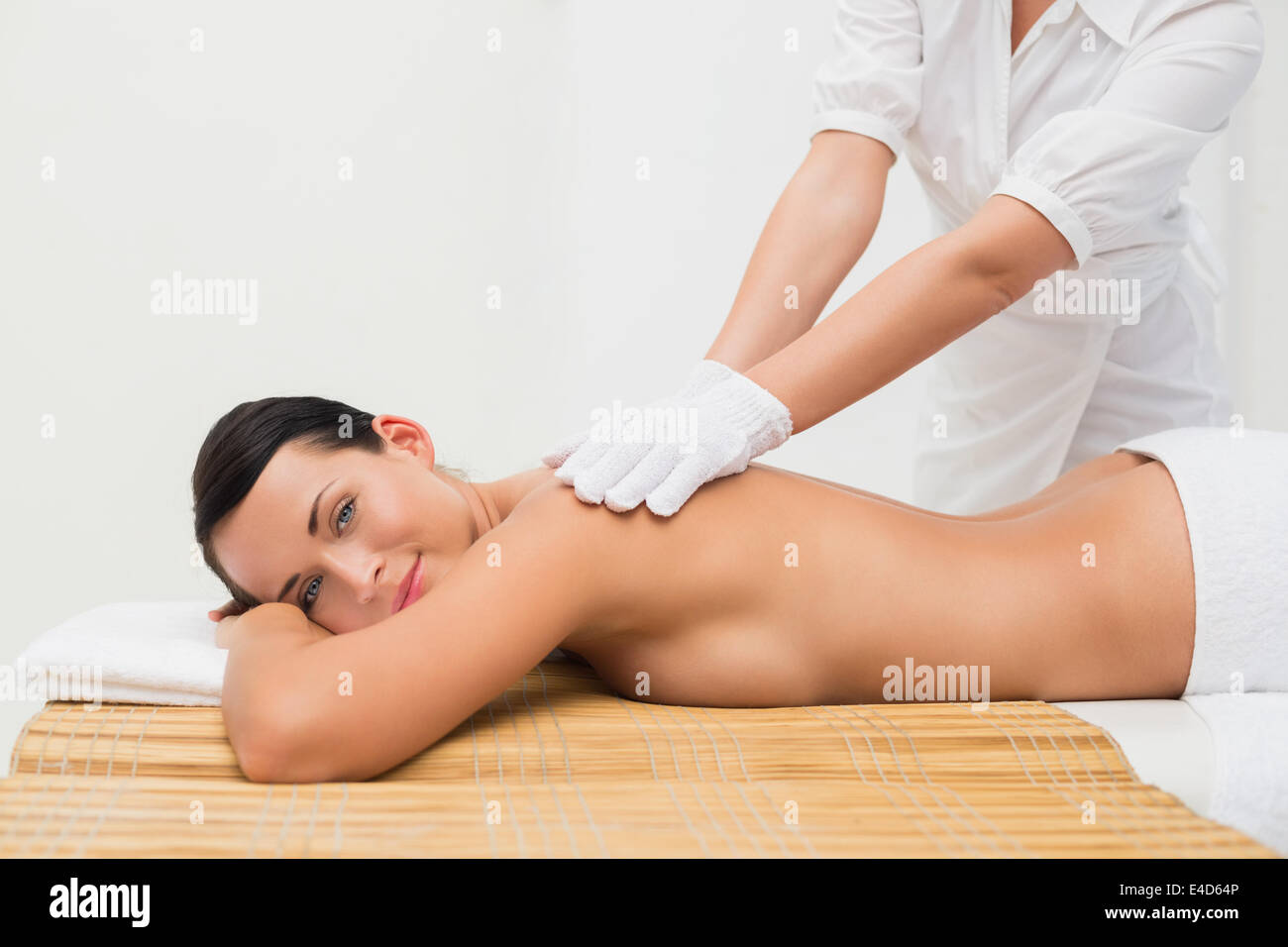 Beautiful brunette enjoying an exfoliating back massage Stock Photo