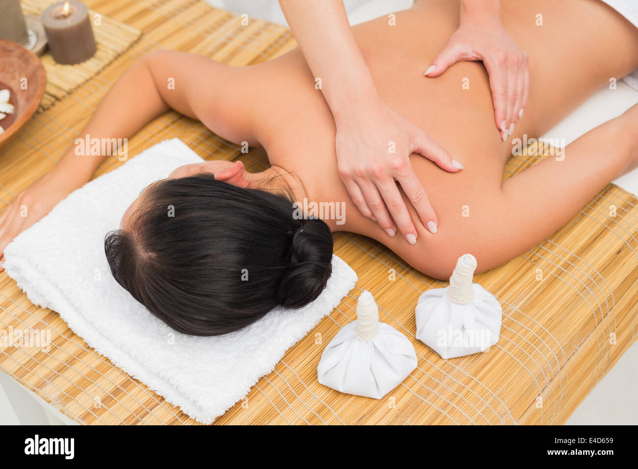 Woman enjoying a herbal compress massage Stock Photo