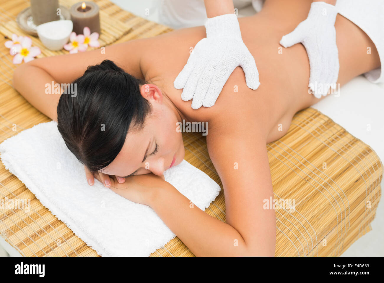 Peaceful brunette enjoying an exfoliating back massage Stock Photo
