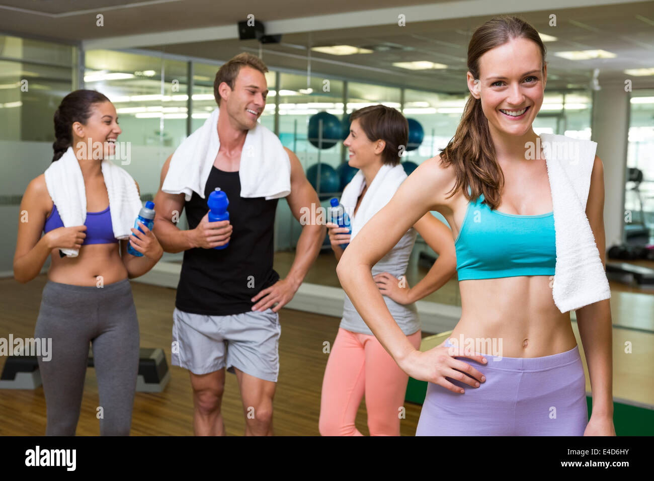 Fit woman smiling at camera in busy fitness studio Stock Photo - Alamy