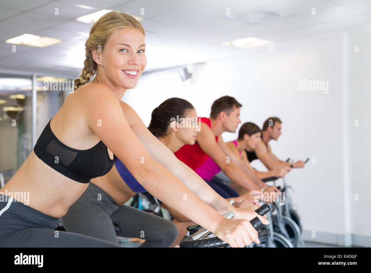 Blonde smiling at camera during spin class Stock Photo - Alamy