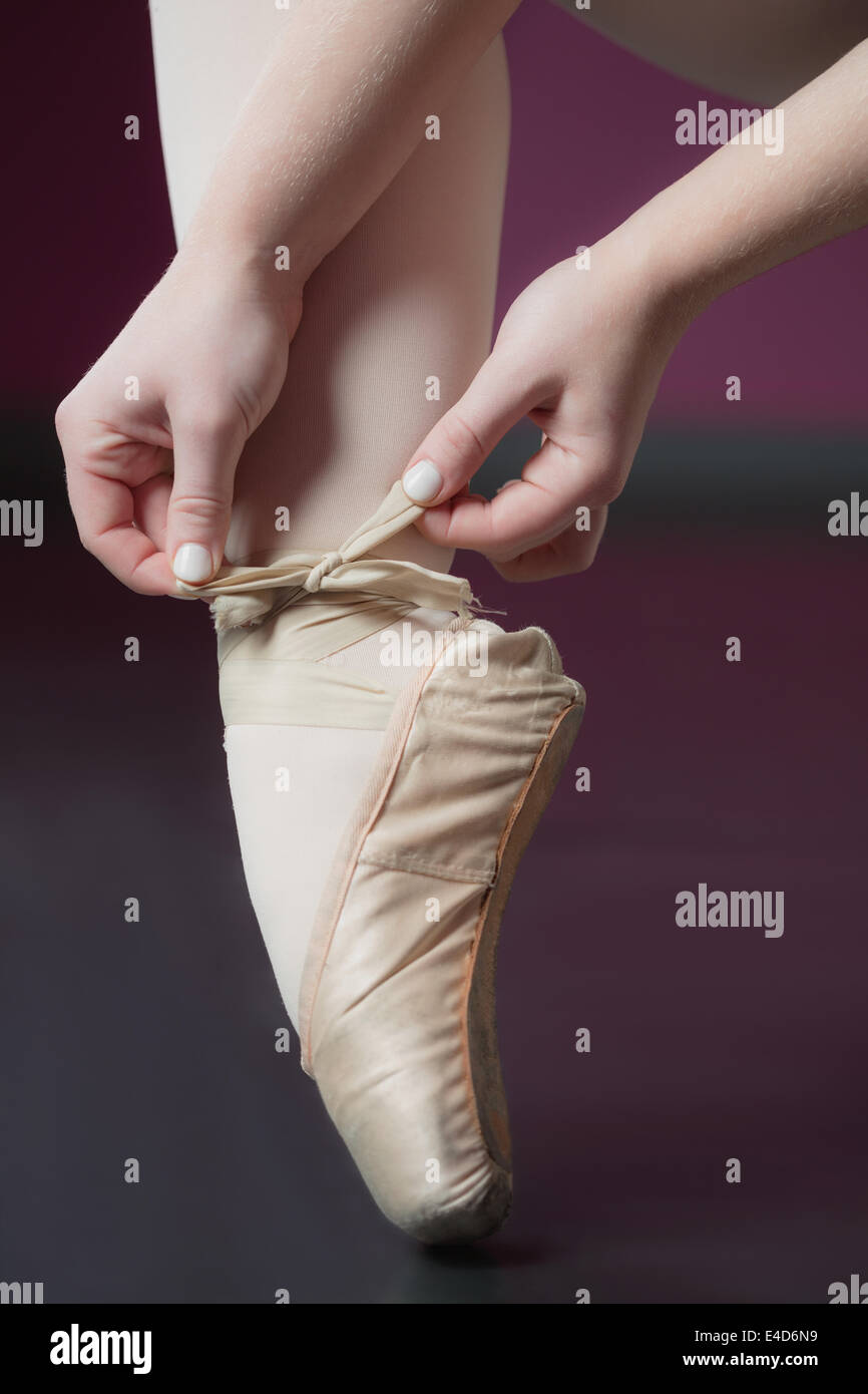 Ballerina tying the ribbon on her ballet slippers Stock Photo Alamy