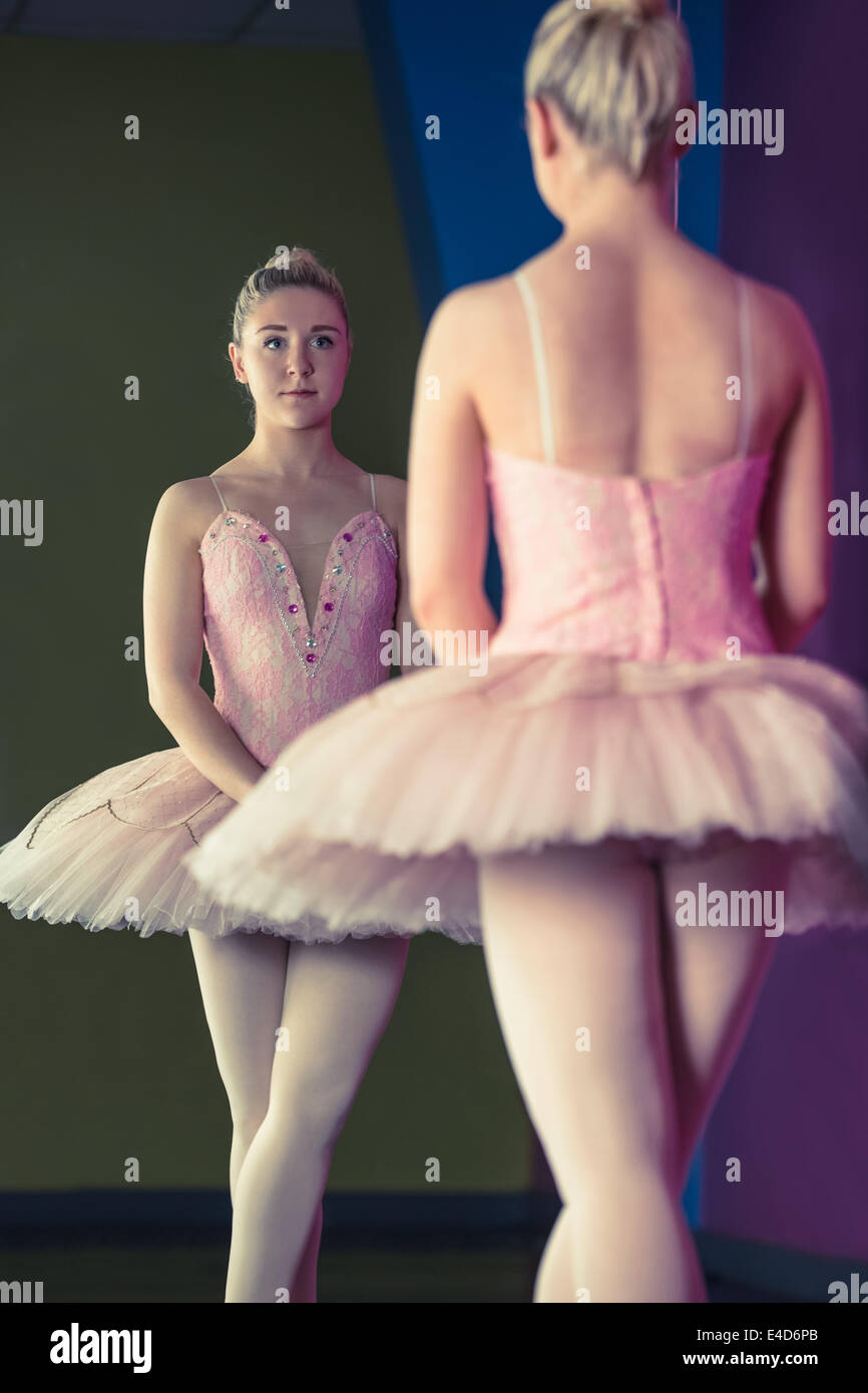 Graceful ballerina standing in first position in front of mirror Stock Photo