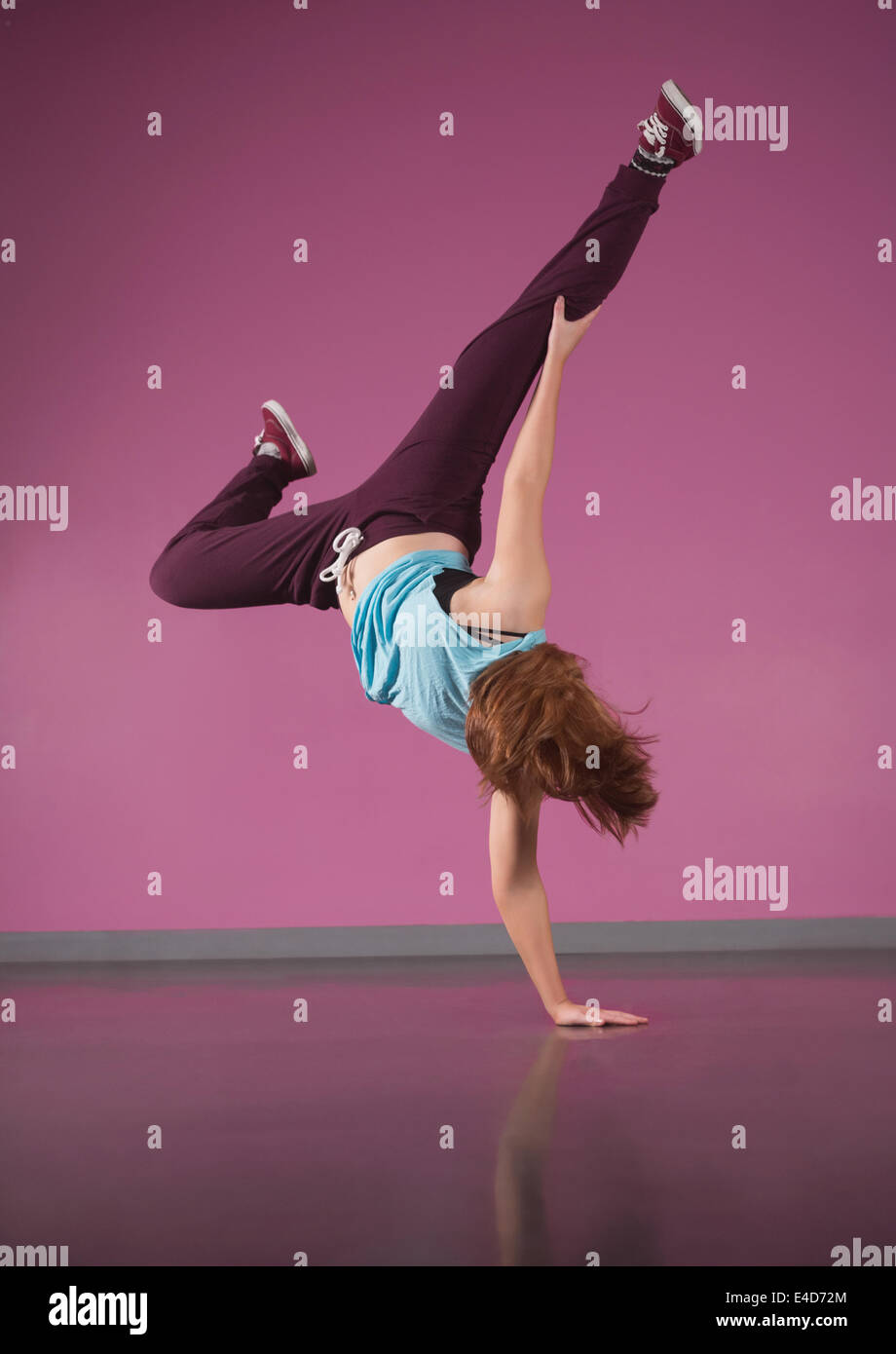 Pretty break dancer doing handstand with one hand Stock Photo