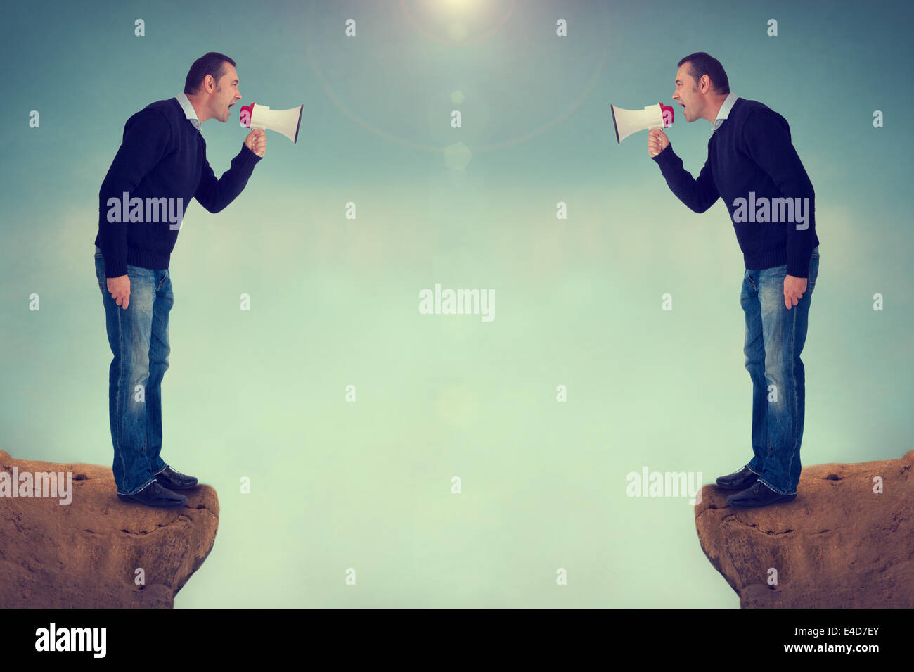 argument quarrel conflict men at loggerheads shouting megaphones over canyon Stock Photo