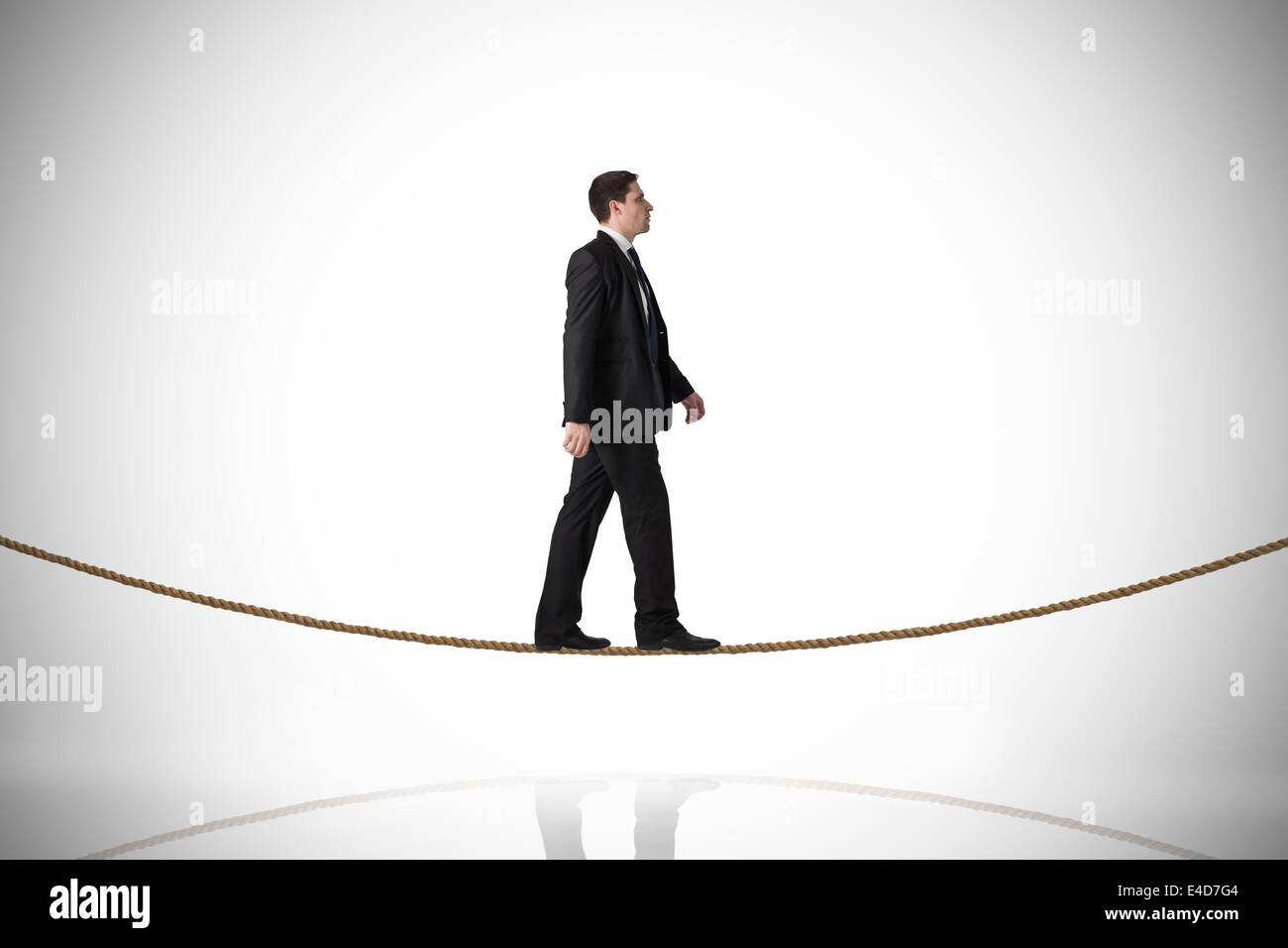 Composite image of handsome businessman stepping on tightrope Stock Photo