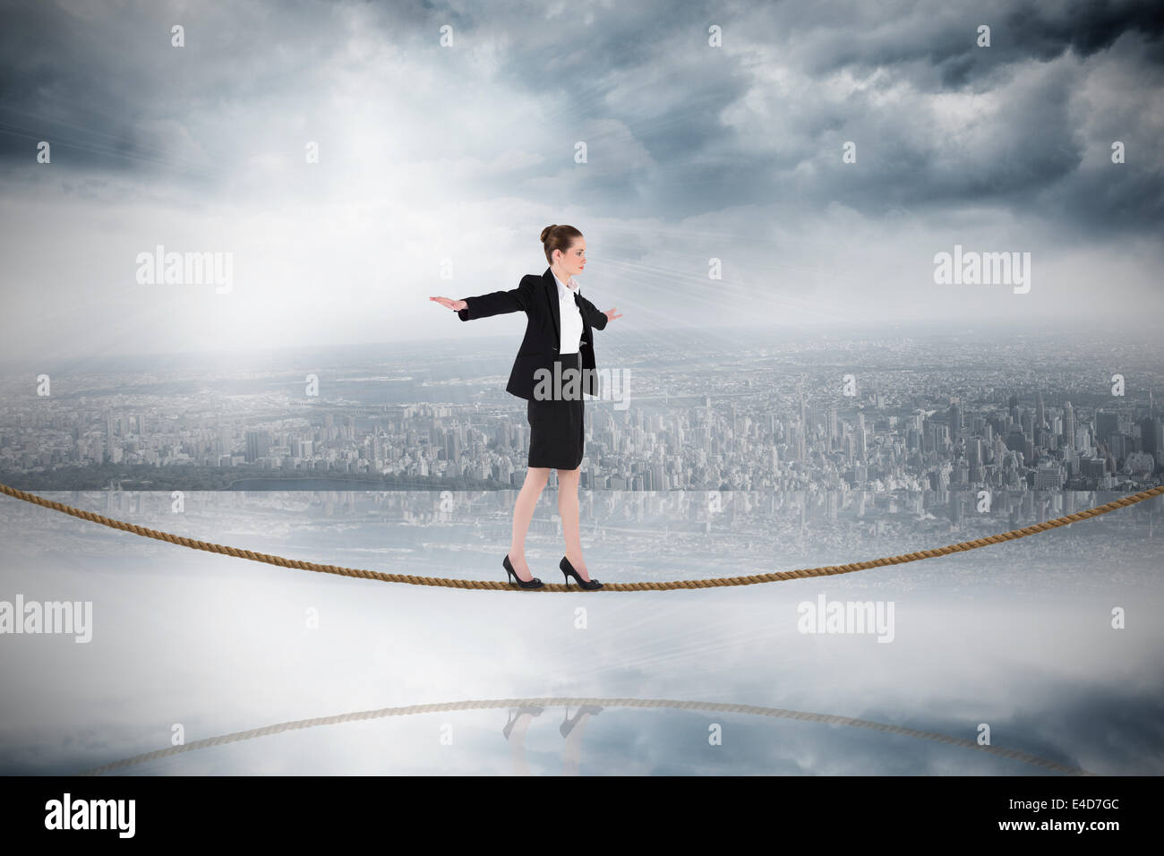 Composite image of businesswoman performing a balancing act on tightrope Stock Photo