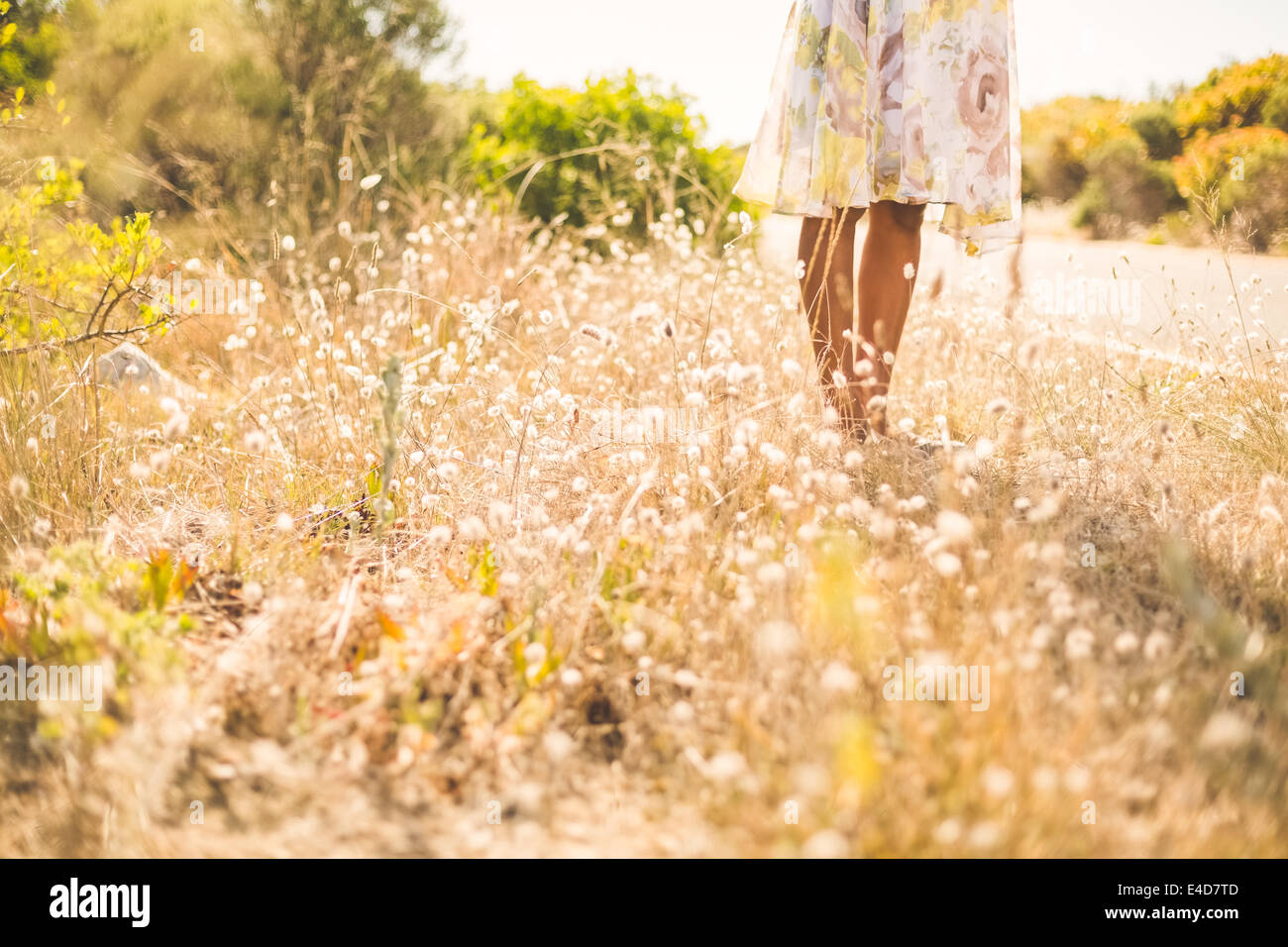 Woman in floral dress standing by the road Stock Photo