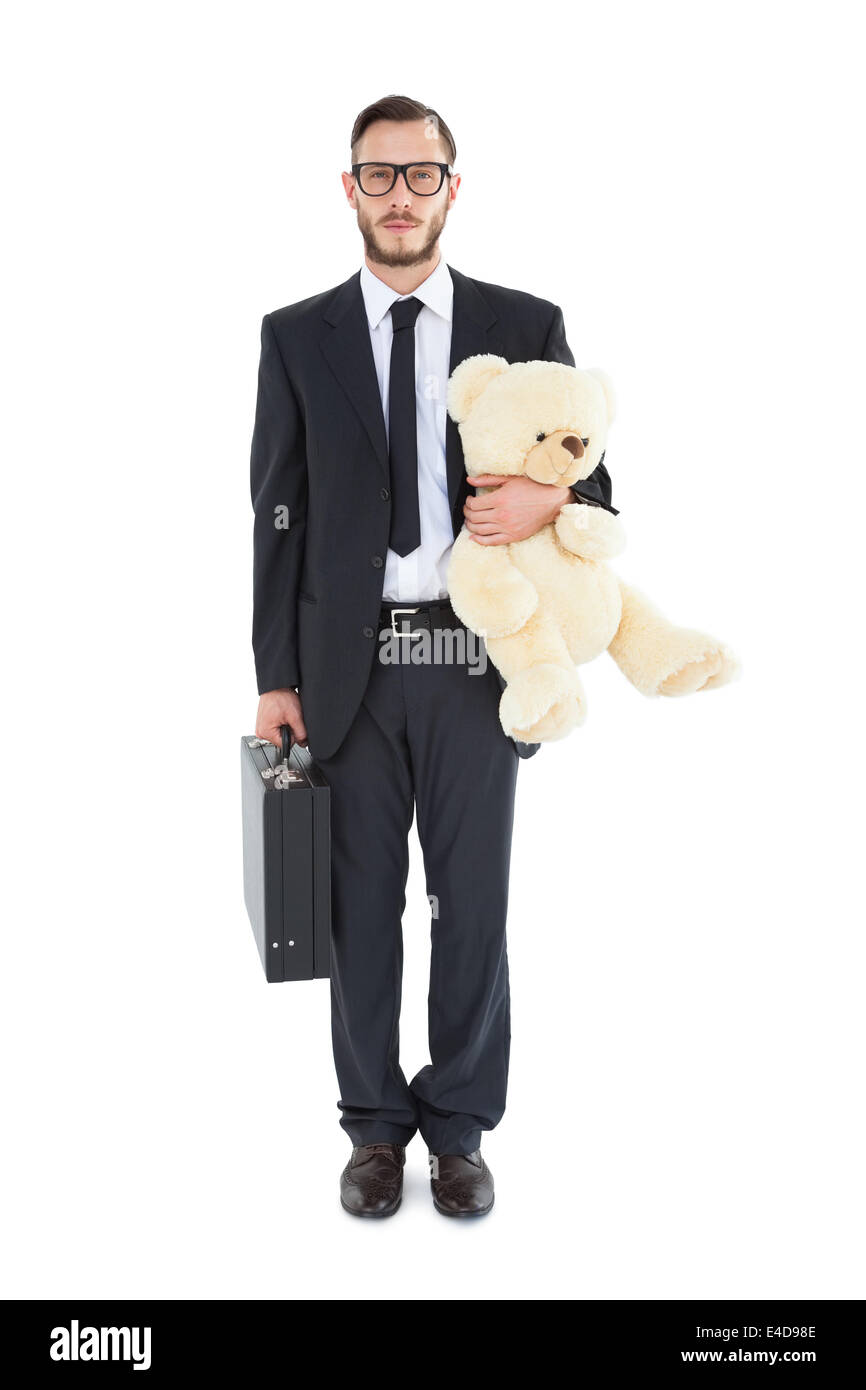 Geeky businessman holding briefcase and teddy Stock Photo