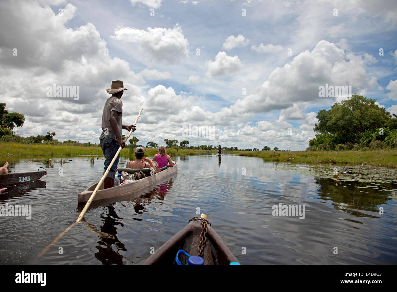 tourists  on a traditional mokoro boat in the Okavango Delta, Botswana, Africa Stock Photo