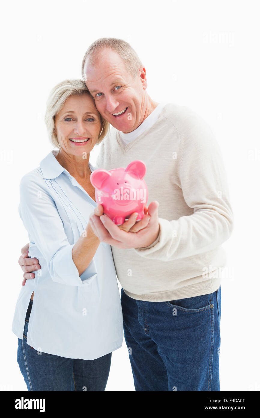 Happy mature couple smiling at camera showing piggy bank Stock Photo ...