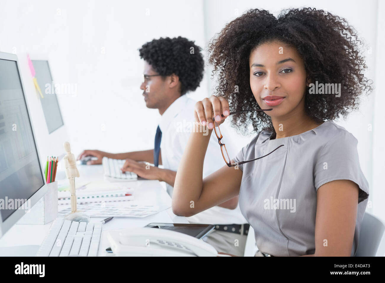 Young editor smiling at camera at her desk Stock Photo Alamy