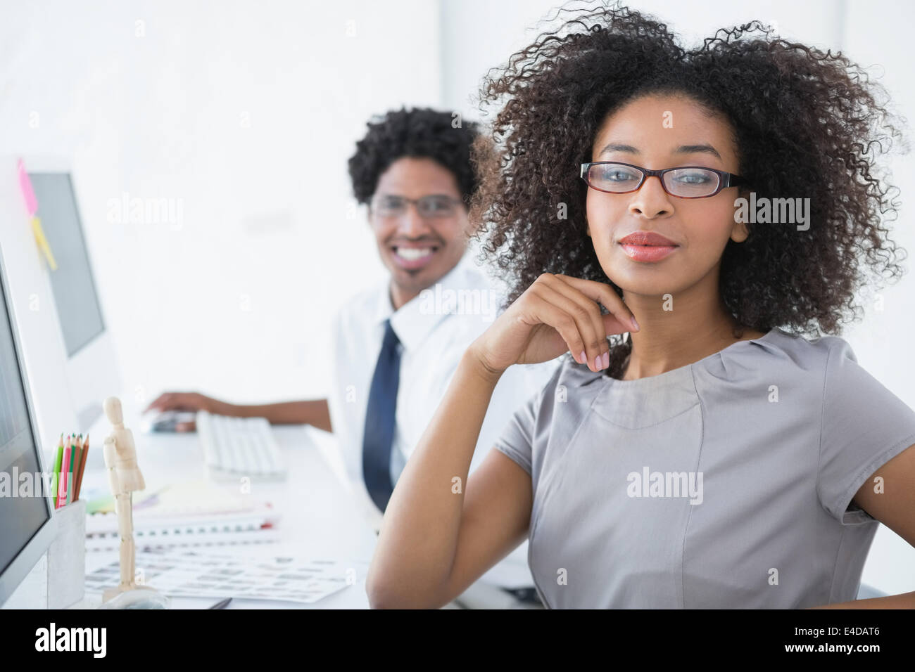 Young editor smiling at camera at her desk Stock Photo Alamy
