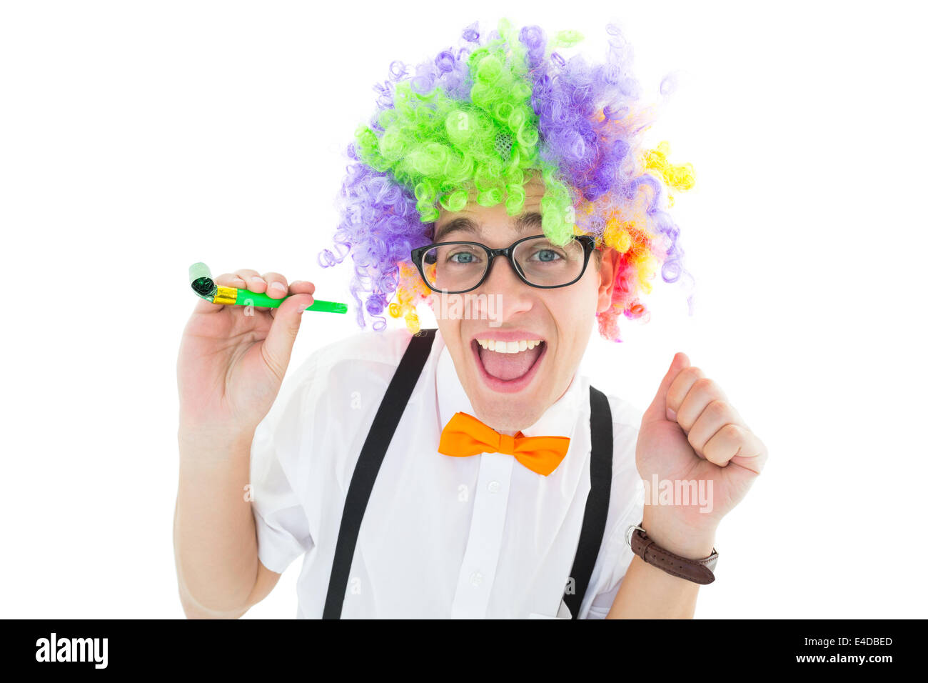 Geeky hipster wearing a rainbow wig holding party horn Stock Photo