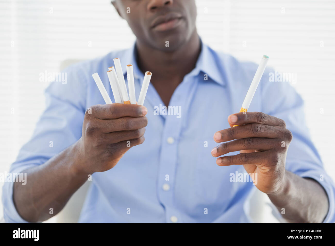 Businessman deciding between electronic or normal cigarettes Stock Photo