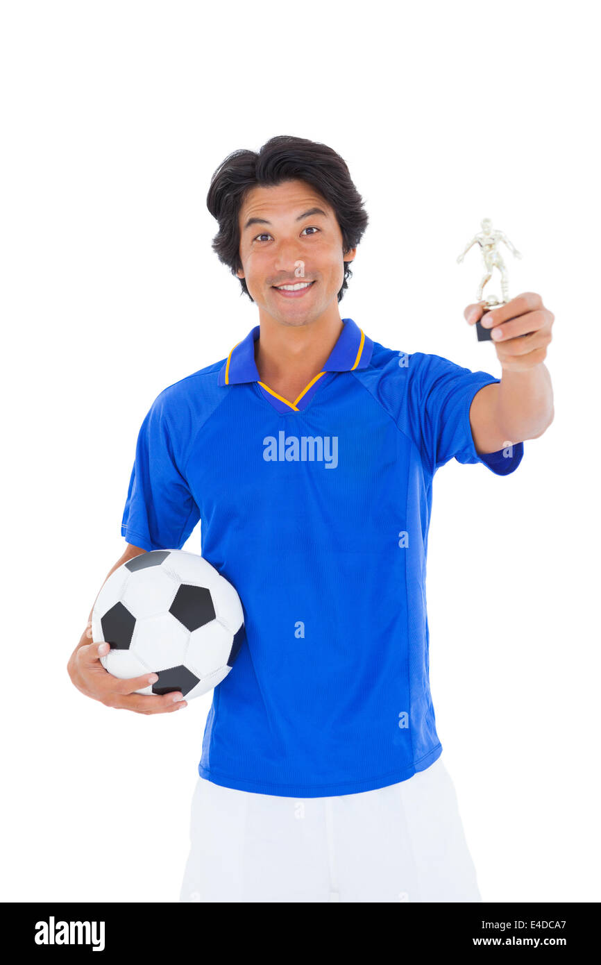Football player in blue holding winners trophy Stock Photo