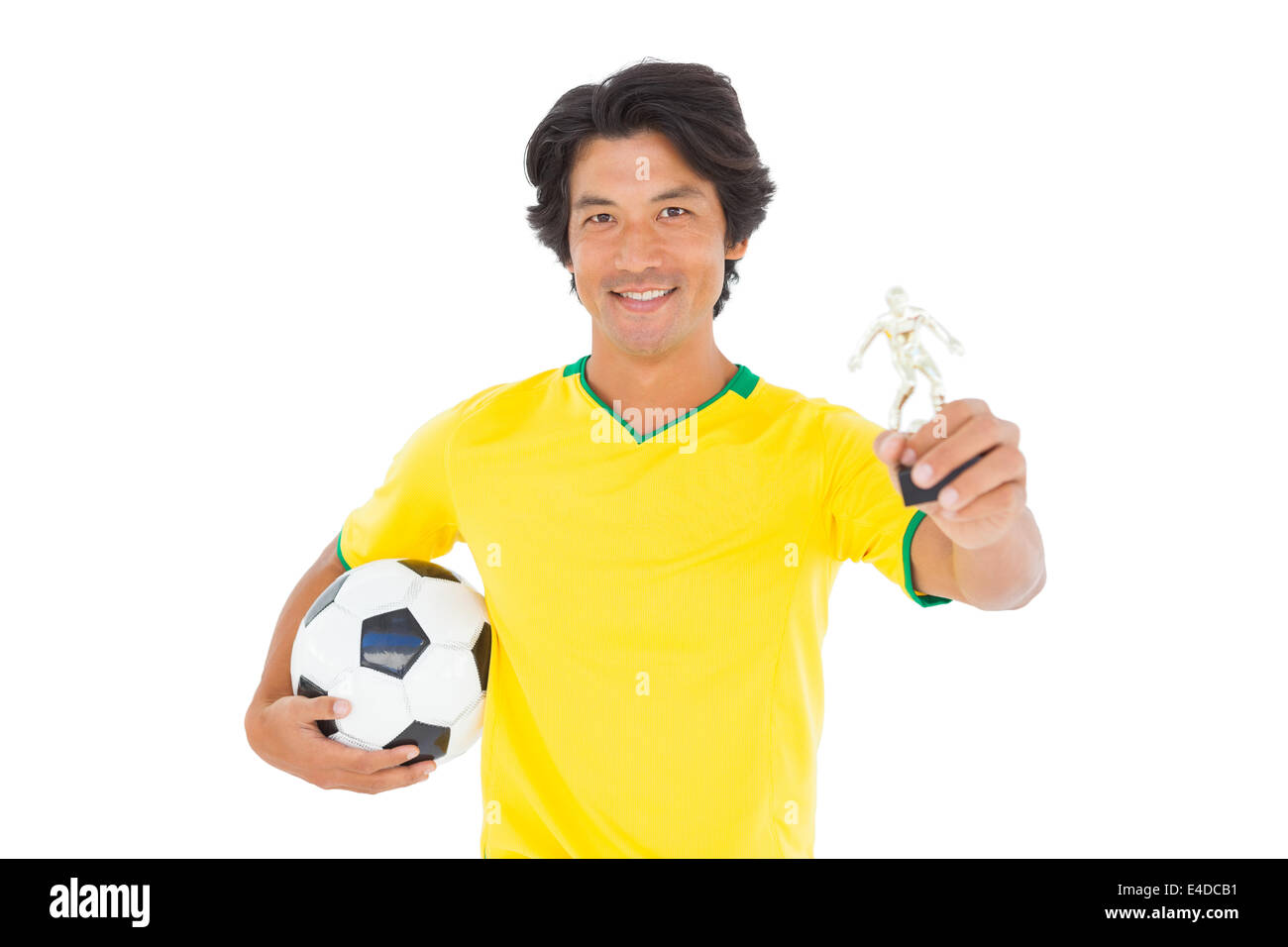 Football player in yellow holding winners trophy Stock Photo