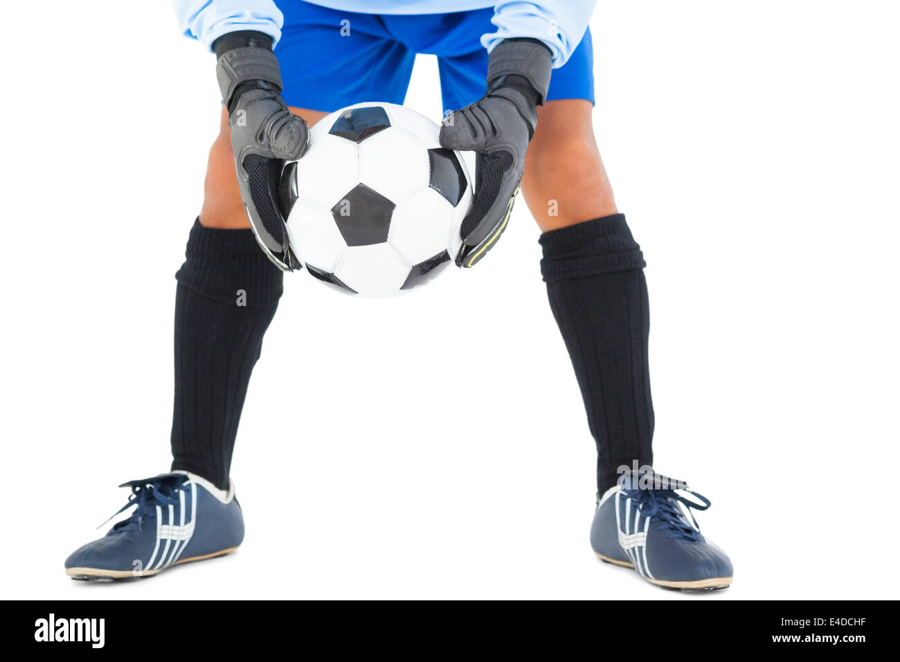 Goalkeeper in blue holding ball Stock Photo