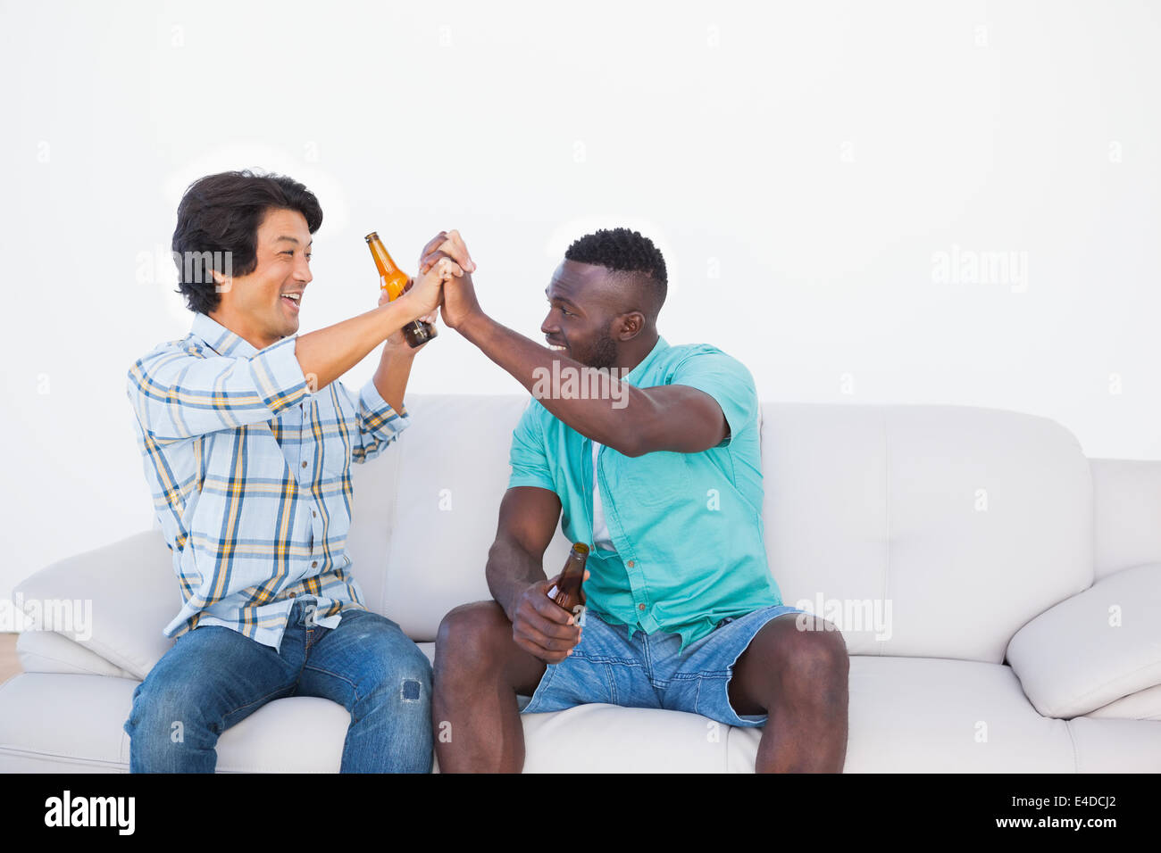 Football fans cheering and holding beer bottles Stock Photo