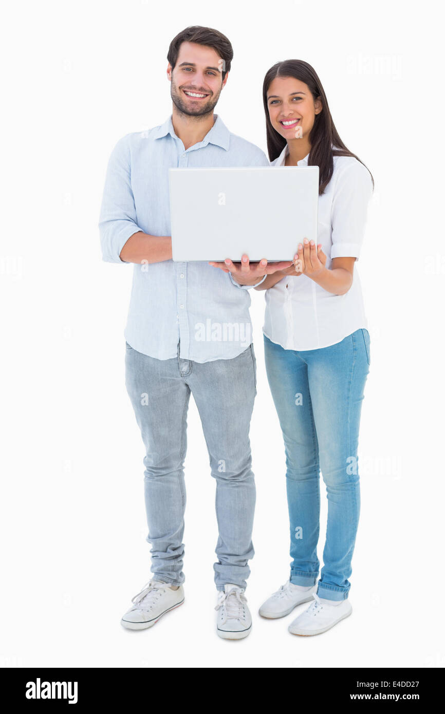 Attractive young couple holding their laptop Stock Photo - Alamy