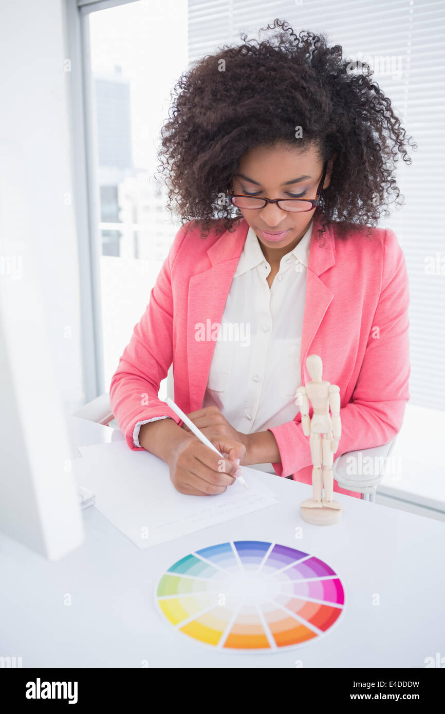 Casual graphic designer working at her desk sketching Stock Photo
