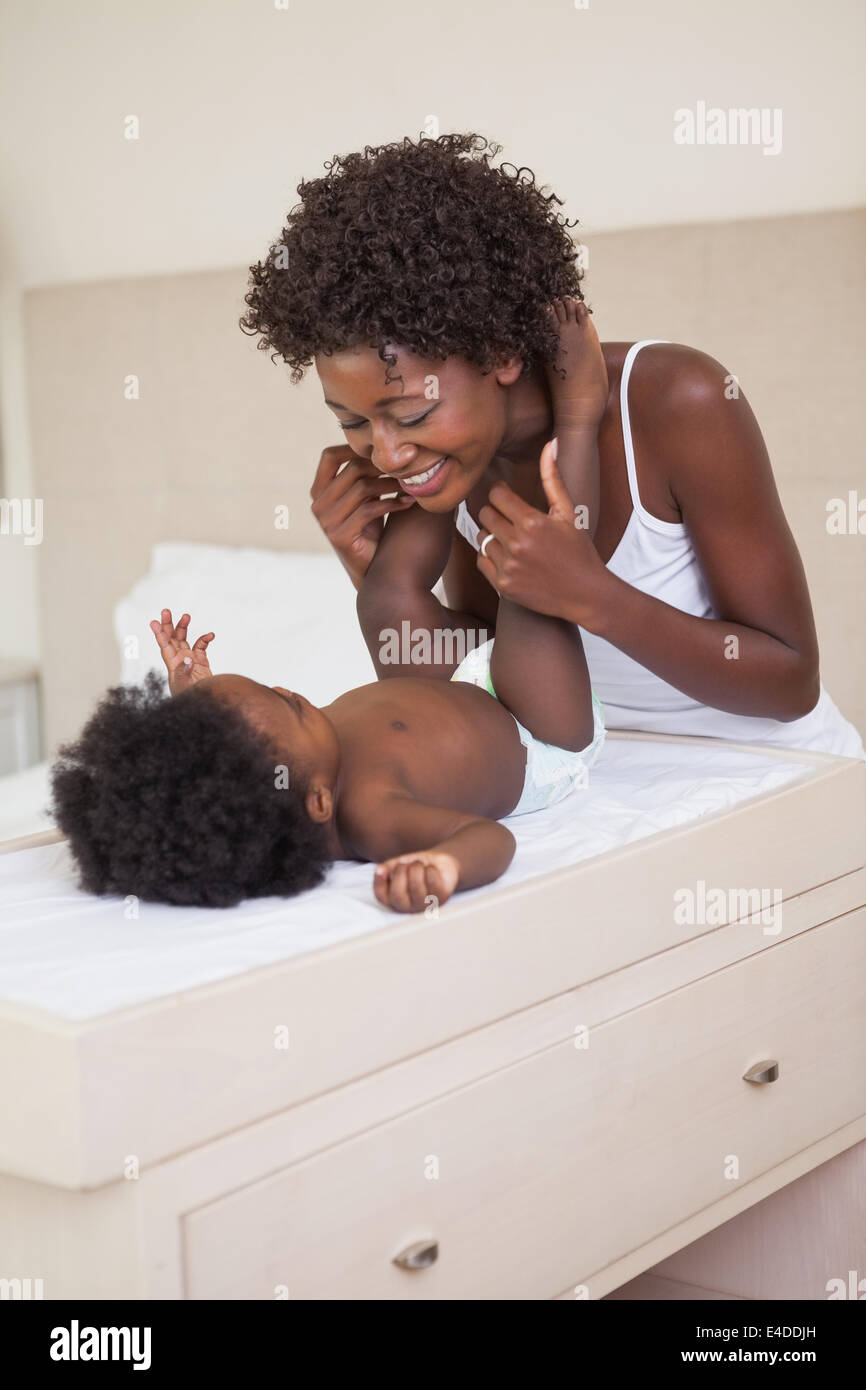 Happy mother with baby girl on changing table Stock Photo