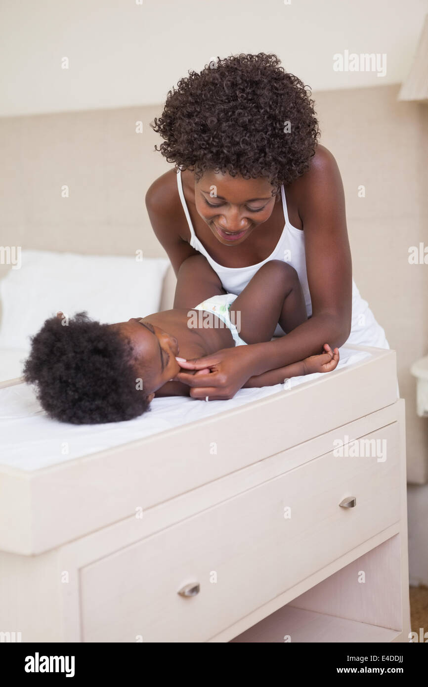 Happy mother with baby girl on changing table Stock Photo