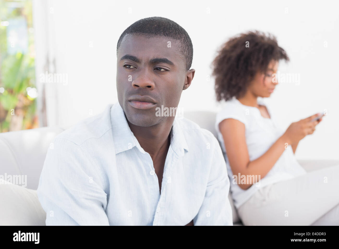 Attractive couple having an argument on couch Stock Photo - Alamy