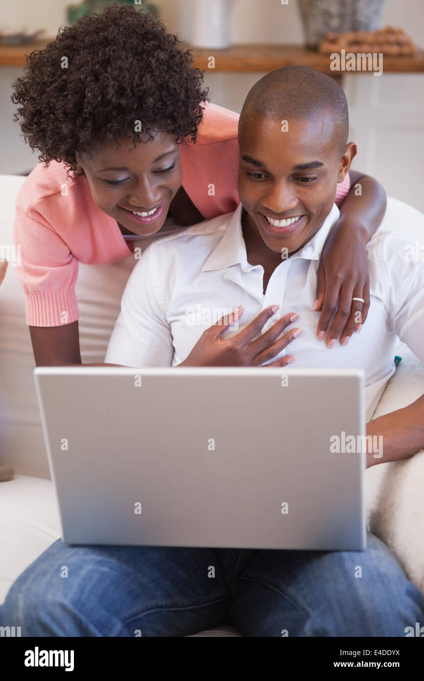 Happy couple relaxing together on the couch using laptop Stock Photo ...