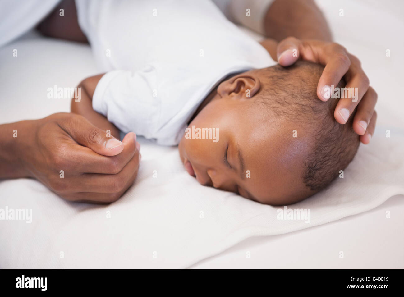 Baby boy sleeping peacefully on couch with father Stock Photo