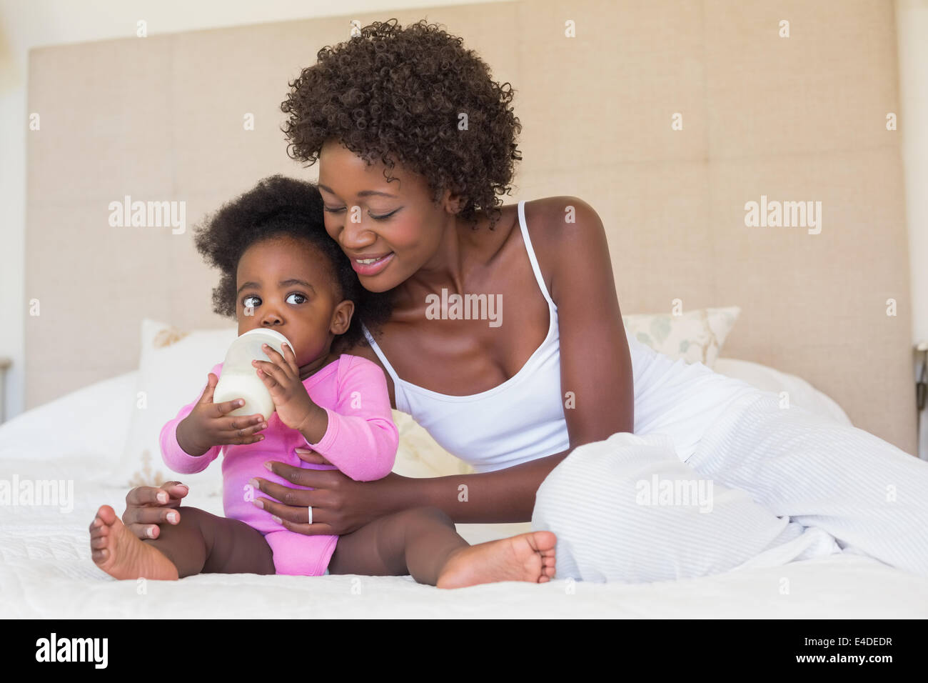 Happy parents with baby girl on their bed Stock Photo