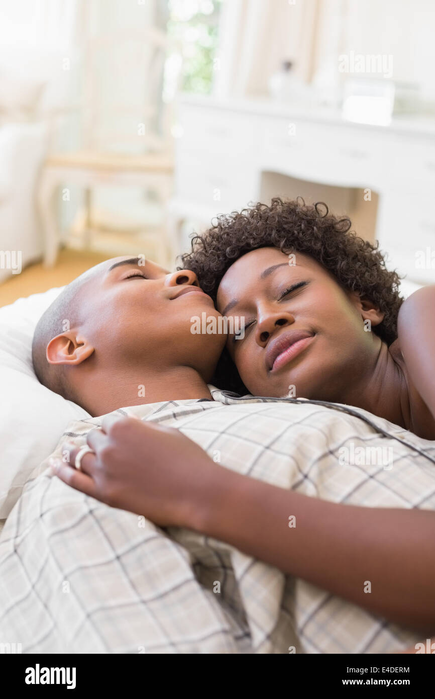 Happy couple lying in bed together Stock Photo - Alamy