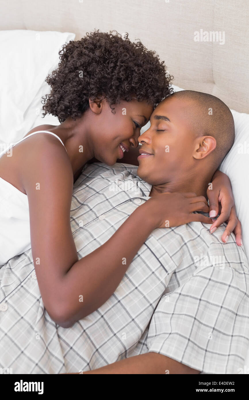 Intimate couple cuddling lying on their bed Stock Photo - Alamy
